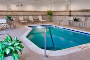 a pool in a hotel lobby with chairs and tables at Fairfield Inn and Suites South Hill I-85 in South Hill