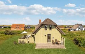 a small yellow house with a roof on a field at Awesome Home In Harbore With Wifi in Harboør