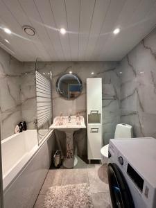 La salle de bains est pourvue d'un lavabo et d'un lave-linge. dans l'établissement Padriku Apartment with a balcony,near to central,Self Check In 24 7,FREE Parking, à Tallinn