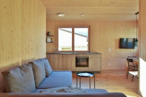 ein Wohnzimmer mit einem blauen Sofa und einer Küche in der Unterkunft Bergreich Appartement 2 in Schoppernau