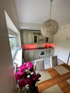 a kitchen with a table and a vase of flowers at Padriku Apartment with a balcony,near to central,Self Check In 24 7,FREE Parking in Tallinn