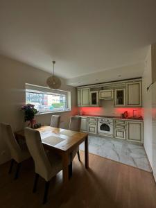 a kitchen with a wooden table and a dining room at Padriku Apartment with a balcony,near to central,Self Check In 24 7,FREE Parking in Tallinn