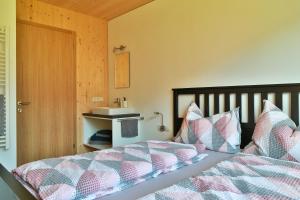 a bedroom with a bed with a comforter and pillows at Bergreich Appartement 2 in Schoppernau