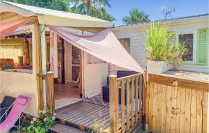 a house with a wooden deck with a tent at Stunning Caravan In Hyres With Wifi And 3 Bedrooms in Hyères