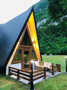 a small cabin with a black roof with two benches at Family S house - Komarnica in Šavnik