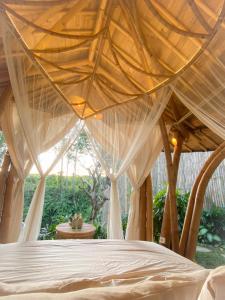 a bedroom with a bed with a net at Wahem Eco Bamboo - Wahem Tebenan in Ubud