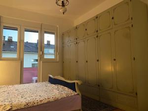- une chambre avec un lit et une grande armoire dans l'établissement DOLCE APARTMAN, à Podgorica