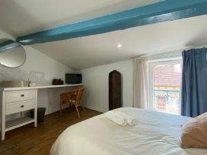 Schlafzimmer mit einem Bett, einem Schreibtisch und einem Fenster in der Unterkunft LE CARNOT - Valence in Bourg-lès-Valence