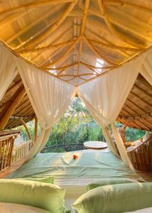 a bed in a room with a wooden ceiling at Wahem Eco Bamboo in Ubud