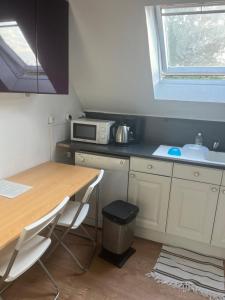 a small kitchen with a table and a microwave at CHAMBRE FamilIale in Nandy