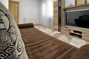 a living room with a couch and a flat screen tv at Alex 2 Apartament in Iaşi