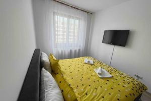 a bedroom with a bed with a yellow comforter at Alex 2 Apartament in Iaşi