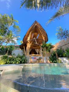 un complexe avec une piscine à côté d'une maison dans l'établissement Wahem Eco Bamboo, à Ubud