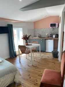 a room with a table and chairs and a kitchen at LE CARNOT - Valence in Bourg-lès-Valence