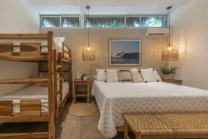 a bedroom with two beds and a bunk bed at Hotel Michanti in El Zonte +219 photos