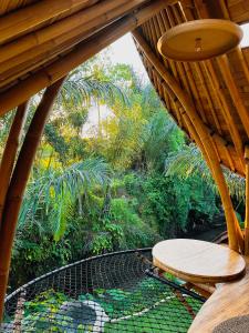 Wahem Eco Bamboo في أوبود: سقف خشبي مع طاولة ومقعد على الفناء