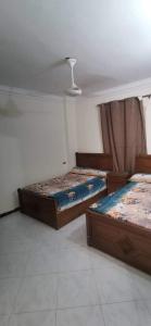 een slaapkamer met 2 bedden en een plafond bij شاليه قريه عايدة -مصر الجديده- عائلات فقط in El Alamein