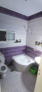 een badkamer met een bad en een toilet en een televisie bij شاليه قريه عايدة -مصر الجديده- عائلات فقط in El Alamein