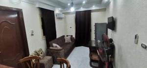 een woonkamer met een bank en een tv bij شاليه قريه عايدة -مصر الجديده- عائلات فقط in El Alamein