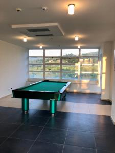 a pool table in the middle of a room with windows at Statera Hotel Village in Poderia