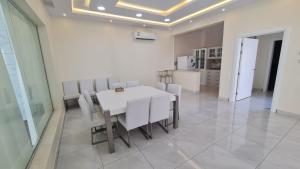 a dining room with a white table and white chairs at فيلا المشراق دورين 4غرف نوم وصالة وصالة معيشة مع شالية ومسبح داخلي in Buraydah