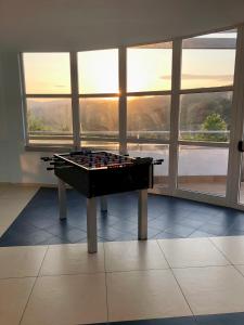 a billiard table sitting in a room with windows at Statera Hotel Village in Poderia