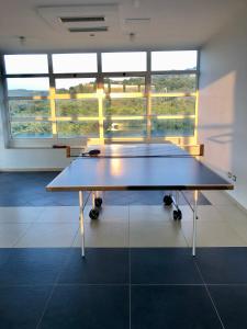 a ping pong table in a room with windows at Statera Hotel Village in Poderia