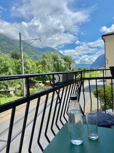 una mesa con 2 vasos en la parte superior de un balcón en Chasa Sassalbo, en Poschiavo