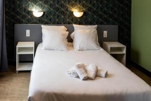 1 cama blanca grande con 2 toallas en Hotel Luxia, en París