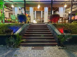 eine Treppe in einem Gebäude mit Blumen in der Unterkunft Sadamadala Guest House Kandy in Kandy