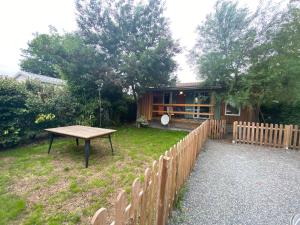 a backyard with a wooden fence and a picnic table at Le chalet Arcachonais in La Teste-de-Buch