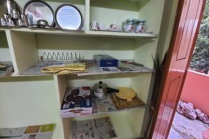 a shelf with some items on it in a room at Newly renovated & furnished 2-Bedroom MVP colony in Visakhapatnam