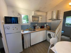 Elle comprend une petite cuisine équipée d'un réfrigérateur et d'un évier. dans l'établissement Le chalet Arcachonais, à La Teste-de-Buch
