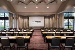 a conference room with tables and chairs and a projector screen at Courtyard by Marriott San Francisco Airport in San Bruno