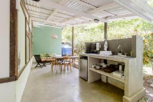 an open kitchen and dining room with a table at Bajo el Arbol B&B in Santa Teresa Beach