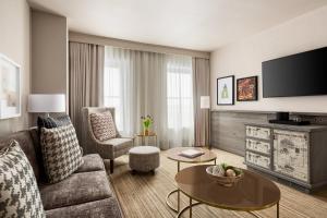 a living room with a couch and a tv at Hotel Northland, Autograph Collection in Green Bay