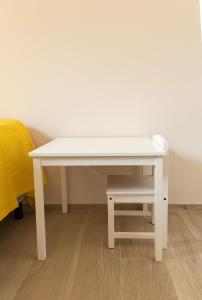 uma mesa branca com um banco ao lado de uma cama em Firenze House Zanella em Florença