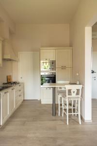 uma cozinha com armários brancos e uma mesa e cadeiras em Firenze House Zanella em Florença
