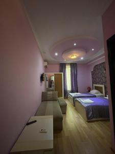 een hotelkamer met 2 bedden en een bank bij Lux Palace Hotel in Koetaisi