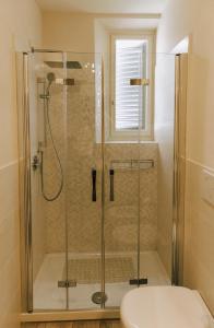 um chuveiro com uma porta de vidro na casa de banho em Firenze House Zanella em Florença