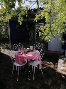 a table with a red and white table cloth on it at Le jardin Renard-Clos sur Loir cottage in the Loir & Loire valleys in La Chapelle-aux-Choux
