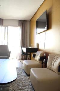 una camera d'albergo con divano e TV di Appt 22 Bloc G- Hicherraton plage Residence Bella Vista, BOUZNIKA BAY a Skhirat