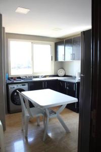 a kitchen with a table and a white table in it at Appt 22 Bloc G- Hicherraton plage Residence Bella Vista, BOUZNIKA BAY in Skhirat