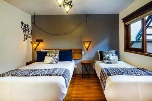 two beds in a room with blue and white at Hotel Kali in Tapalpa