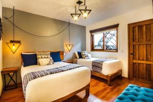 sypialnia z 2 łóżkami i oknem w obiekcie Hotel Kali w mieście Tapalpa