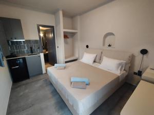 um quarto com uma grande cama branca com duas toalhas em Meridiano em Parikia