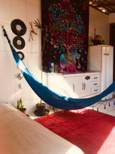 a blue hammock in a room with a red rug at Hostel Uai in Ouro Preto