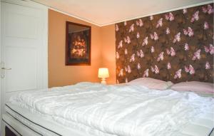 a bedroom with a large white bed with a floral wall at Pet Friendly Home In Backaryd With House A Panoramic View in Backaryd