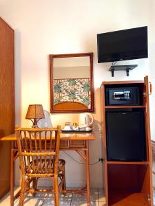 Cette chambre comprend un bureau avec une télévision et un miroir. dans l'établissement Casa Famiani Bed & Breakfast, à Letojanni