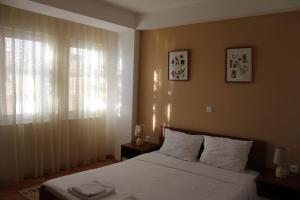 a bedroom with a bed with white sheets and a window at Vila Kumani in Ohrid